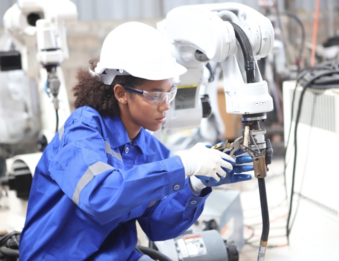 Robotics technician assembling a robotic component in a shop.