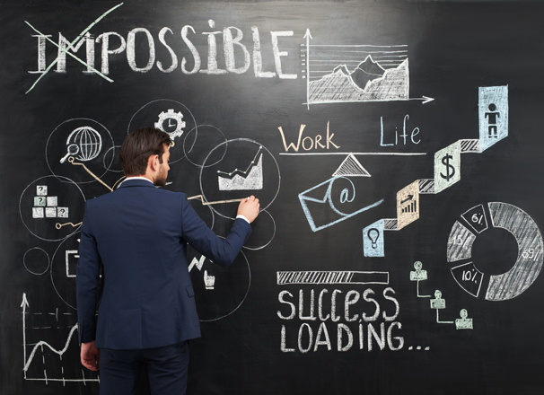 Person wearing business suit drawing on a chalkboard
