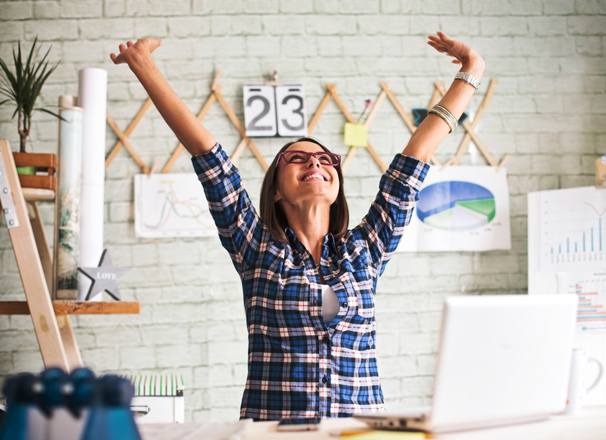 Person in an office throwing hands up in the air in excitement