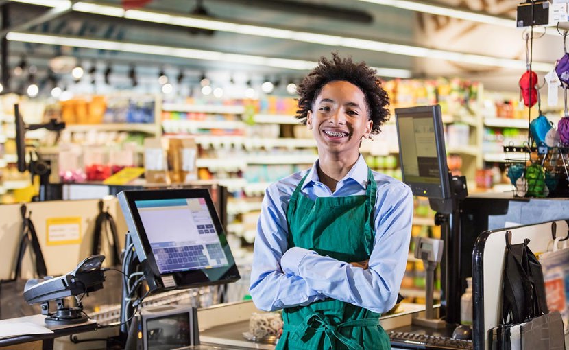 A portrait of a young cashier at a grocery store.