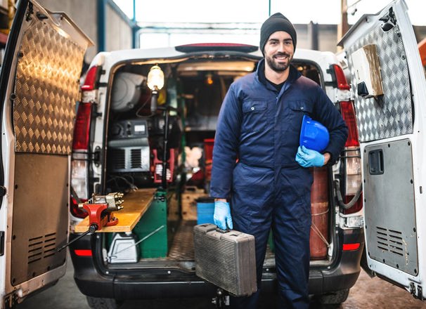 Mechanic standing in front of the opened back doors of a van