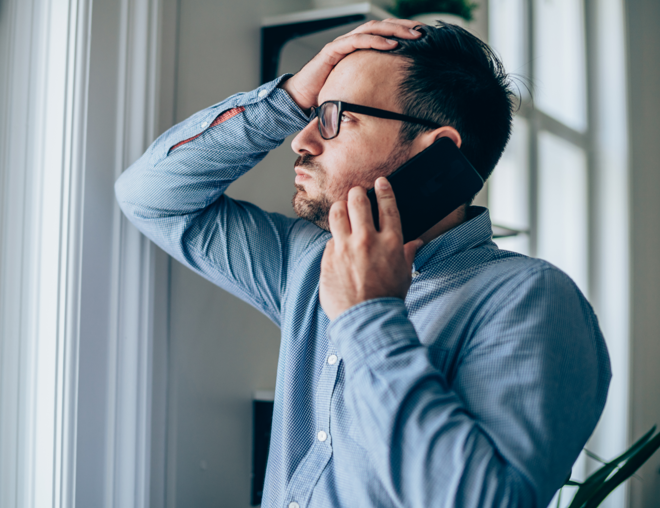 Man looking worried while talking on cell phone.