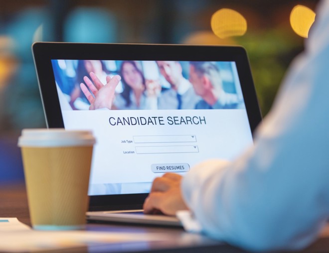 Employer using software on laptop to find candidates for job. 