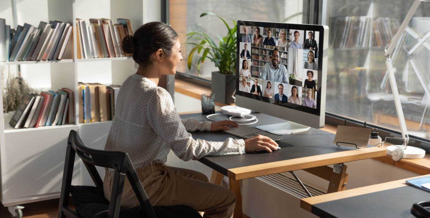 Person video conferencing with a group of people from desktop computer. 