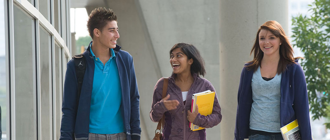 3 students walking outside on campus