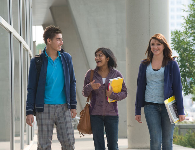 3 students walking outside on campus