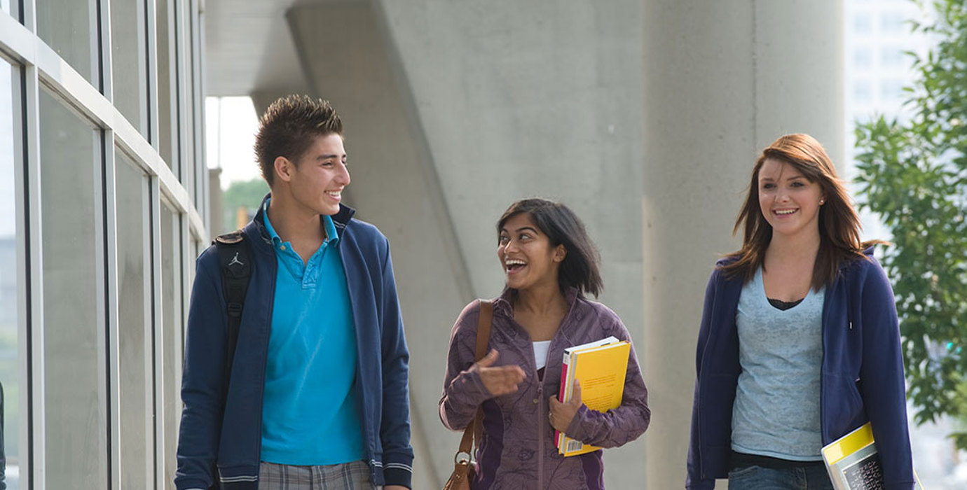 3 students walking outside on campus