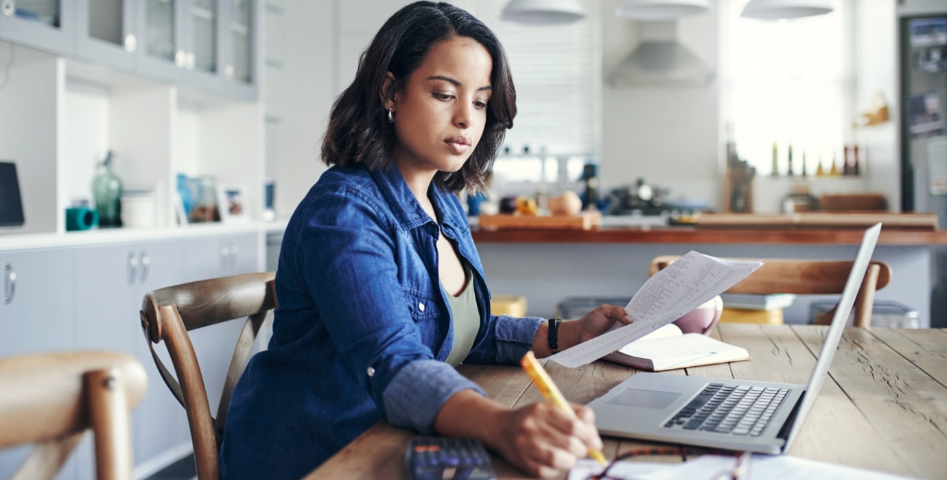 Person reviewing their finances at their kitchen table.
