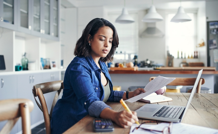 Person reviewing their finances at their kitchen table.