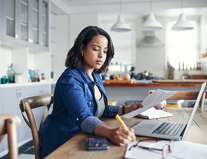 Person reviewing their finances at their kitchen table.