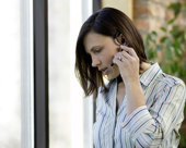 Person talking on the phone using a headset while looking at documents