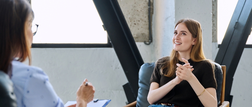 Career counsellor speaking with a client in an office.
