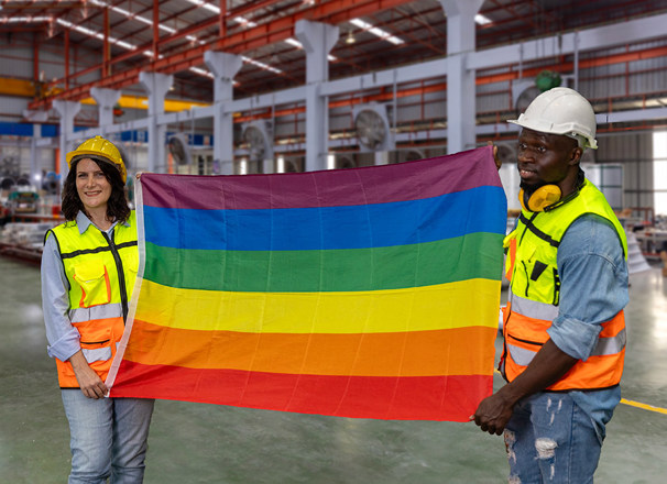 2 employees holding gay pride flag in factory