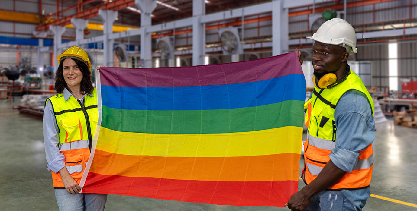 2 employees holding gay pride flag in factory