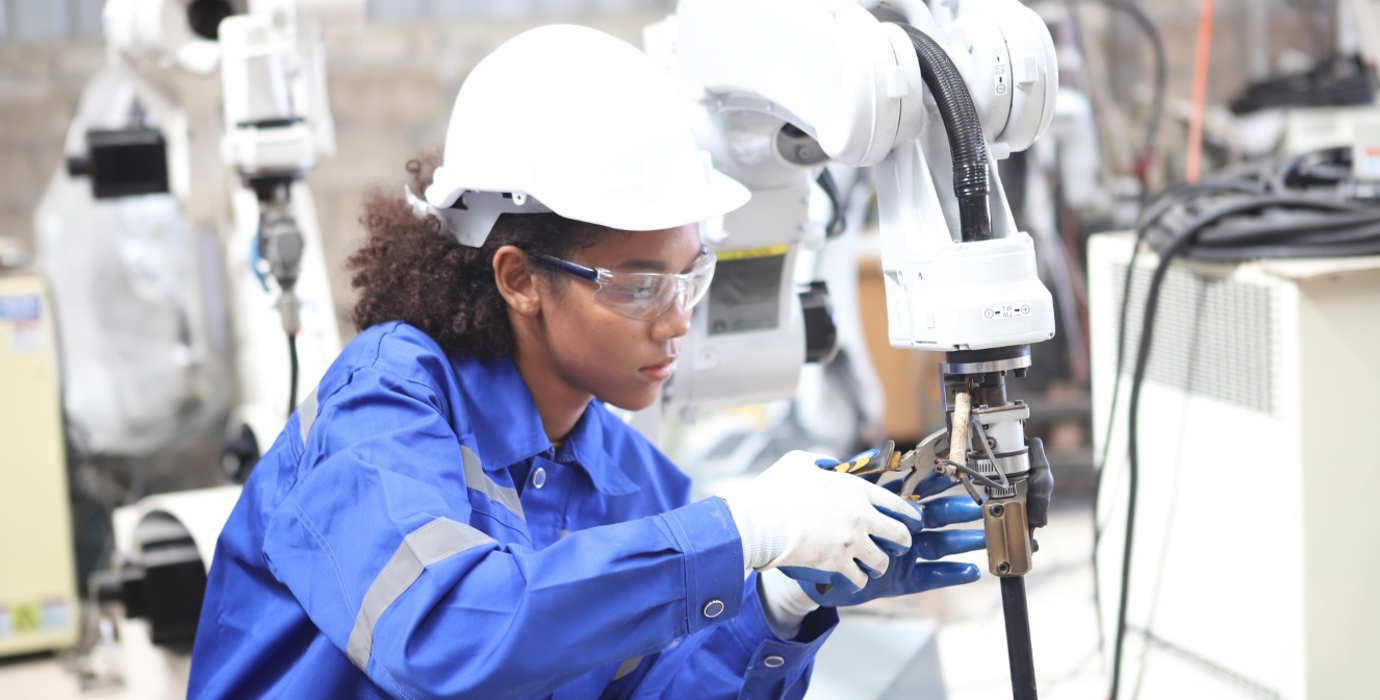 Robotics technician assembling a robotic component in a shop. 