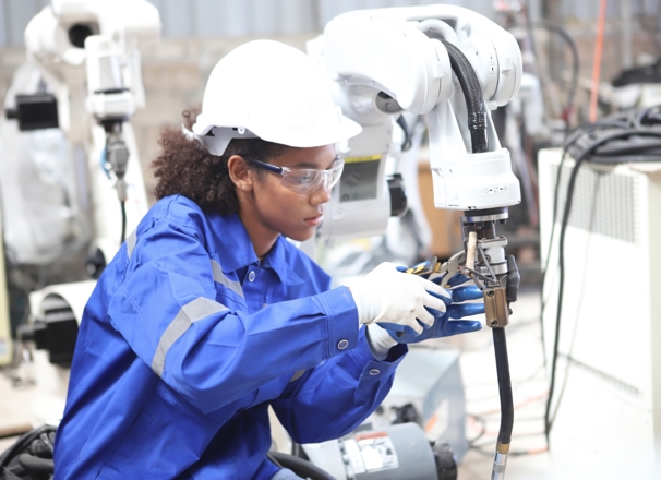 Robotics technician assembling a robotic component in a shop.