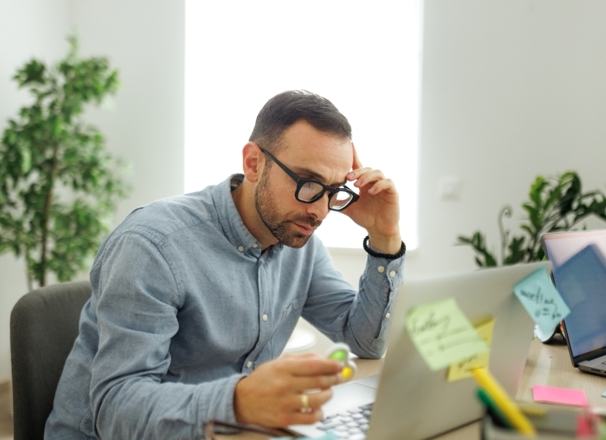 Worker at desk using a fidget spinner while looking at laptop. 