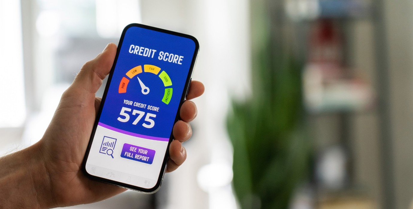 Hand holding a phone that has a credit score rating system on the screen.