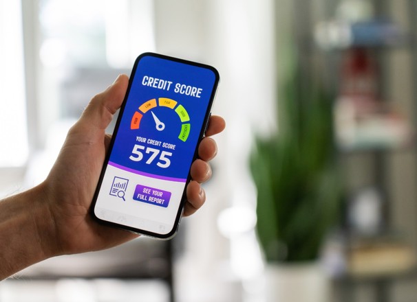 Hand holding a phone that has a credit score rating system on the screen.