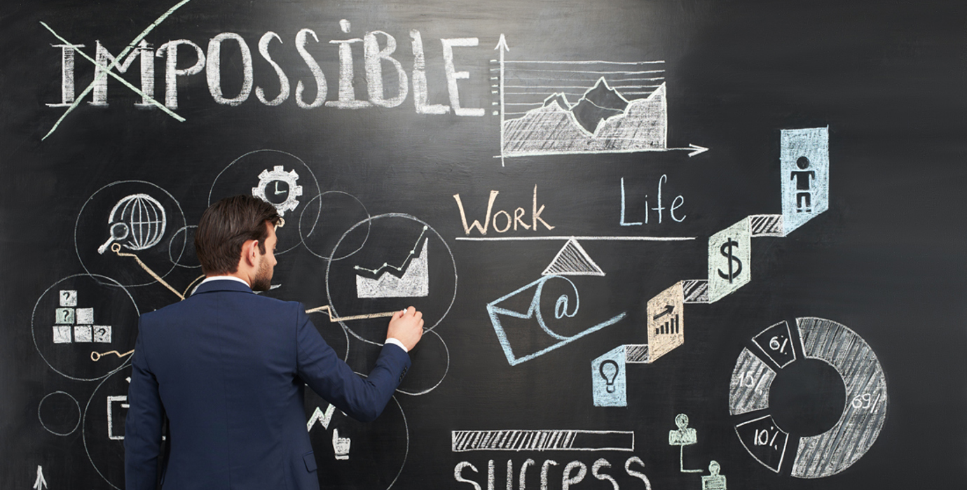 Person wearing business suit drawing on a chalkboard