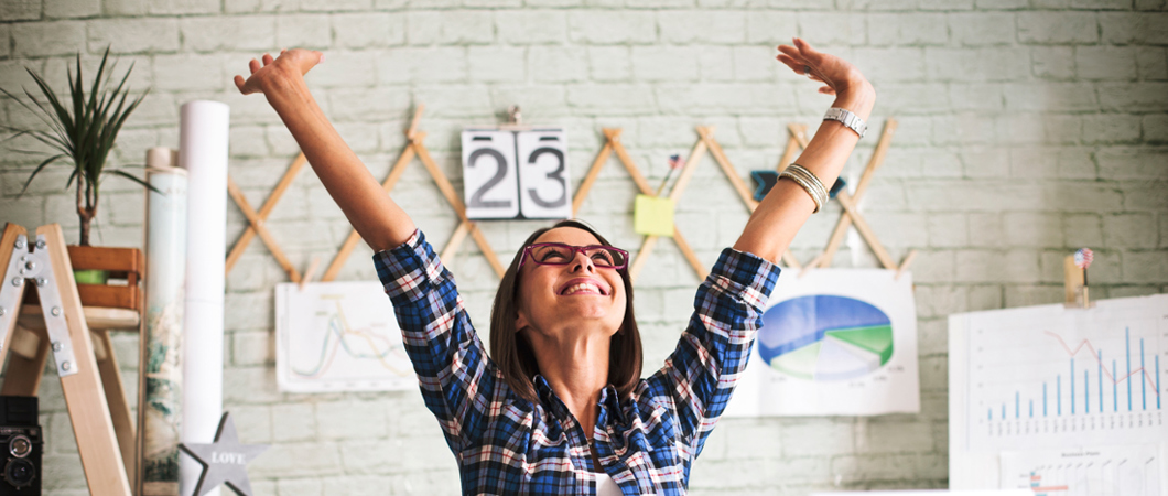 Person in an office throwing hands up in the air in excitement