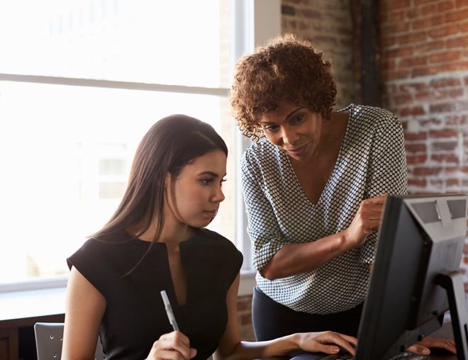 Youth and adult discussion in an office with computer