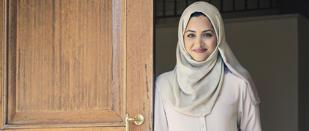 Person smiling while leaning against an open door