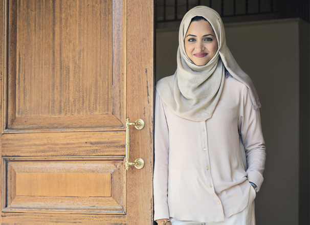 Person smiling while leaning against an open door