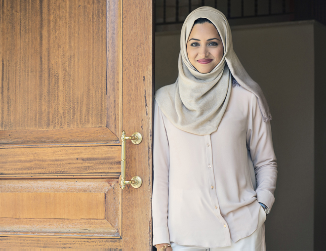 Person smiling while leaning against an open door