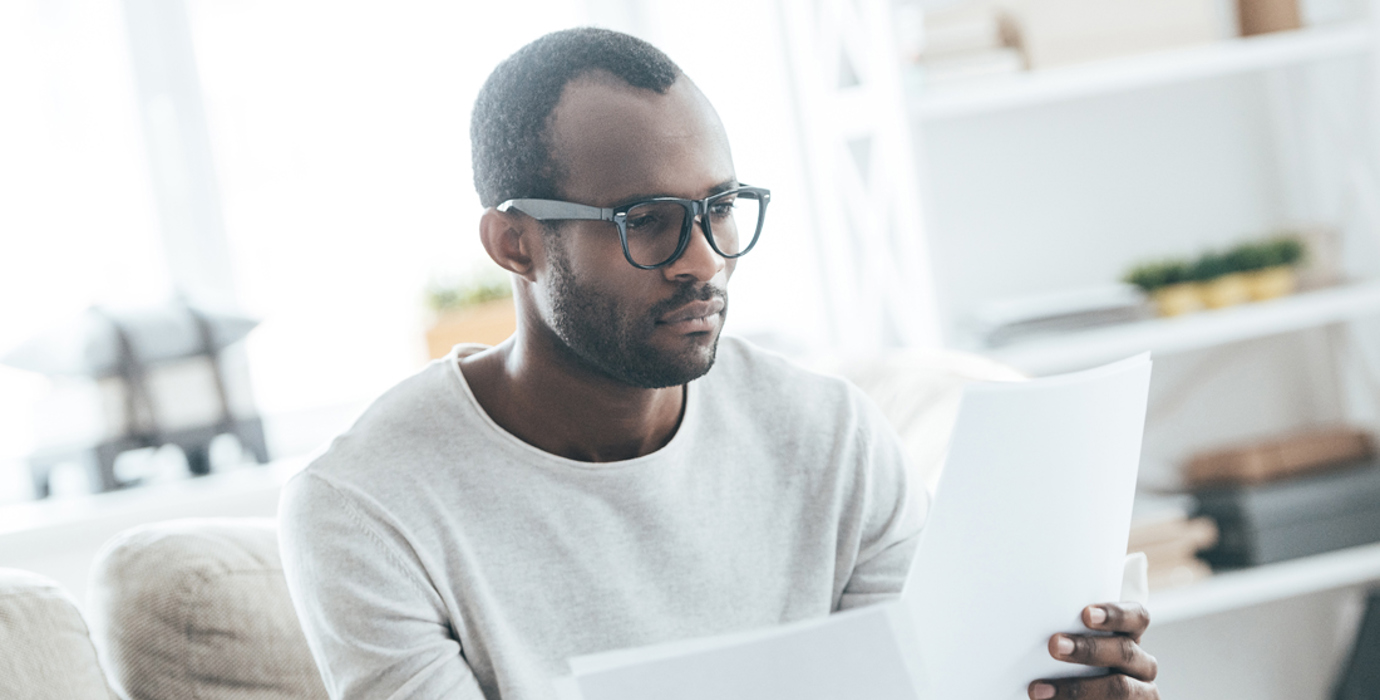 Person sitting on a couch reading documents