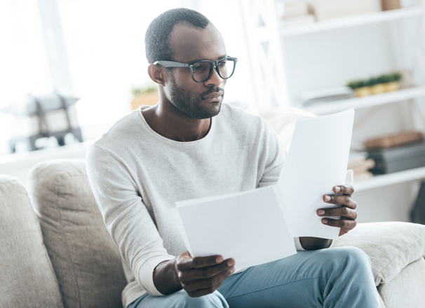 Person sitting on a couch reading documents