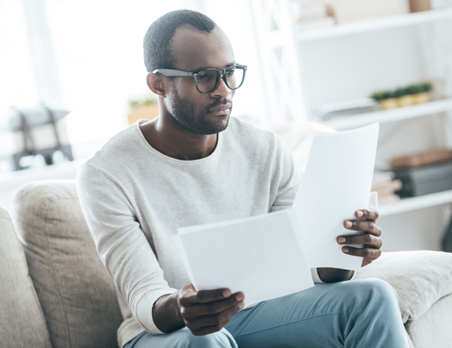Person sitting on a couch reading documents