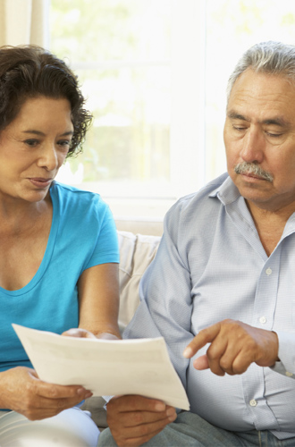 Couple looking at paperwork on the couch