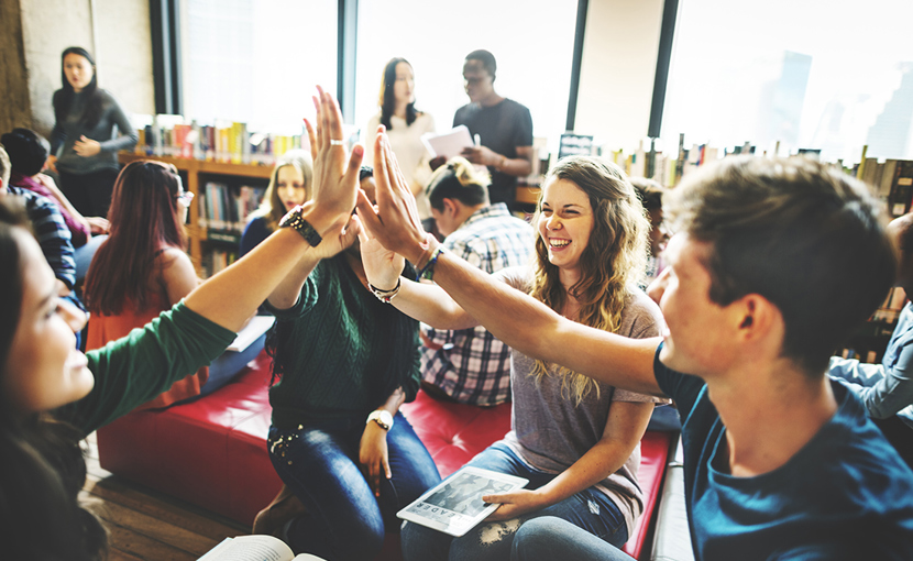 Students high fiving in a library