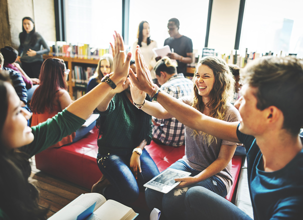 Students high fiving in a library