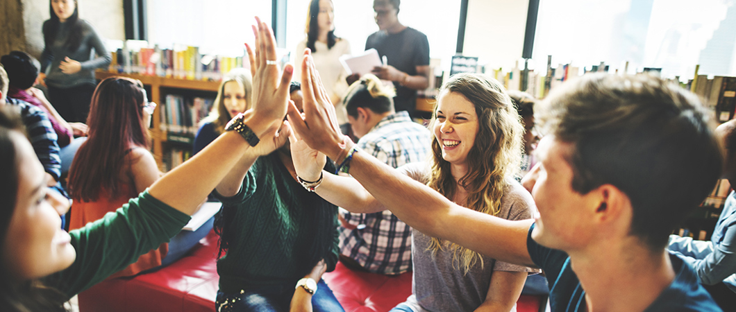 Students high fiving in a library