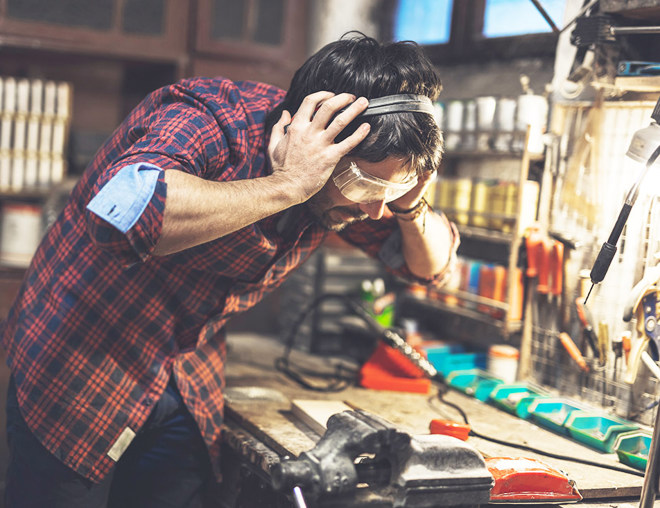 Person grabbing on to ear protection in a workshop