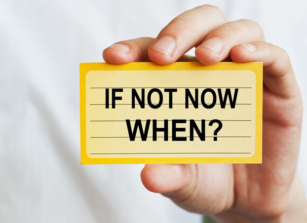 Hand holding up an index card with the message, "If not now, when?"