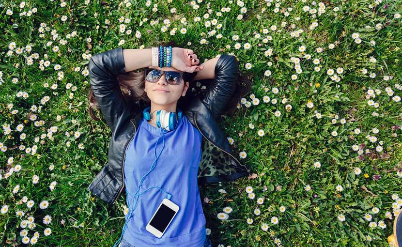 Youth smiling and lying on the grass