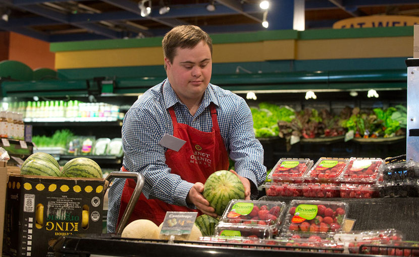 Employee working a the produce area of a grocery store