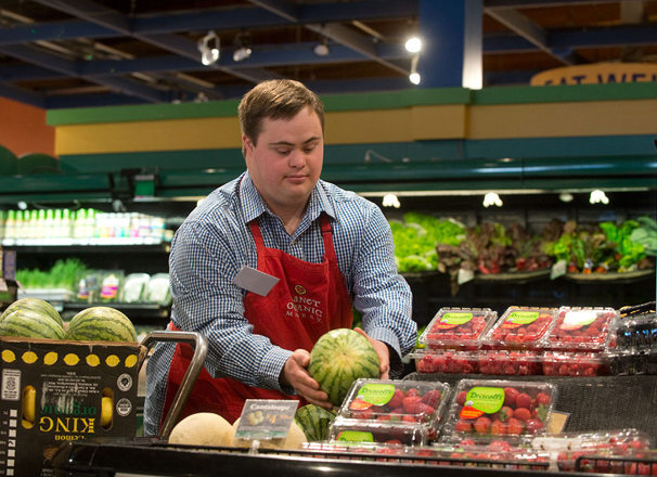 Employee working a the produce area of a grocery store