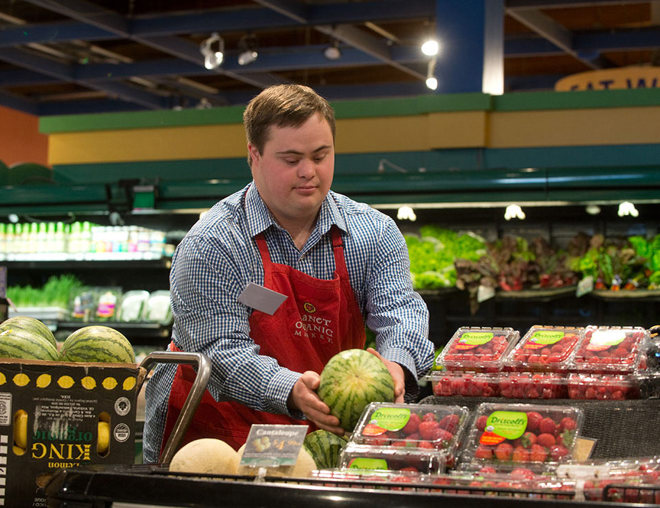 Employee working a the produce area of a grocery store