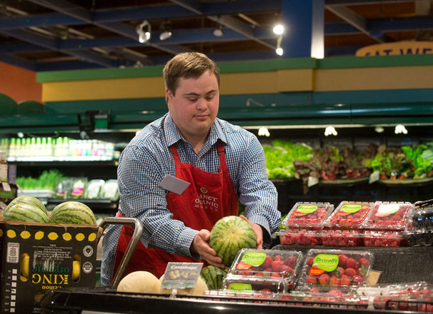 Employee working a the produce area of a grocery store