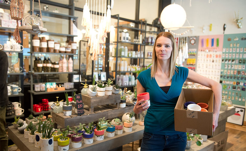 Entrepreneur holding a box of pottery in a store