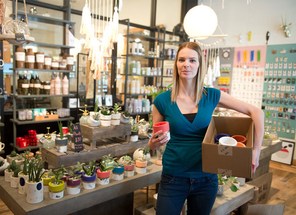 Entrepreneur holding a box of pottery in a store