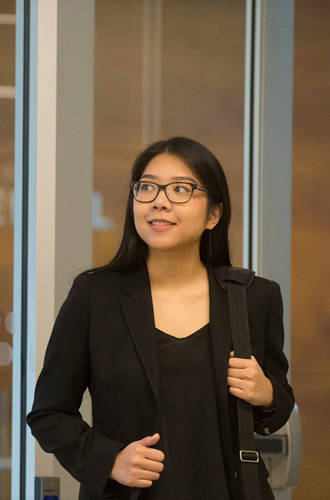 Person wearing business attire standing in the doorway with a "Join our team" sign posted