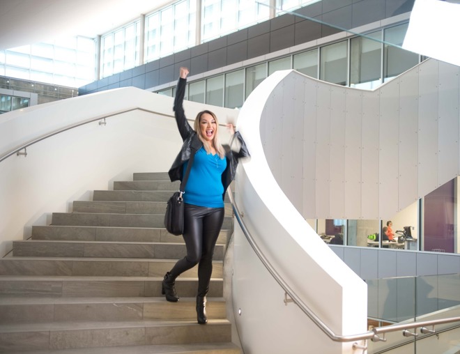 Student happily walking down the stairs with a fist pump