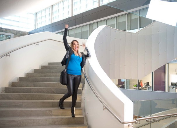 Student happily walking down the stairs with a fist pump