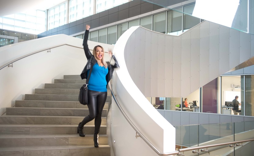 Student happily walking down the stairs with a fist pump
