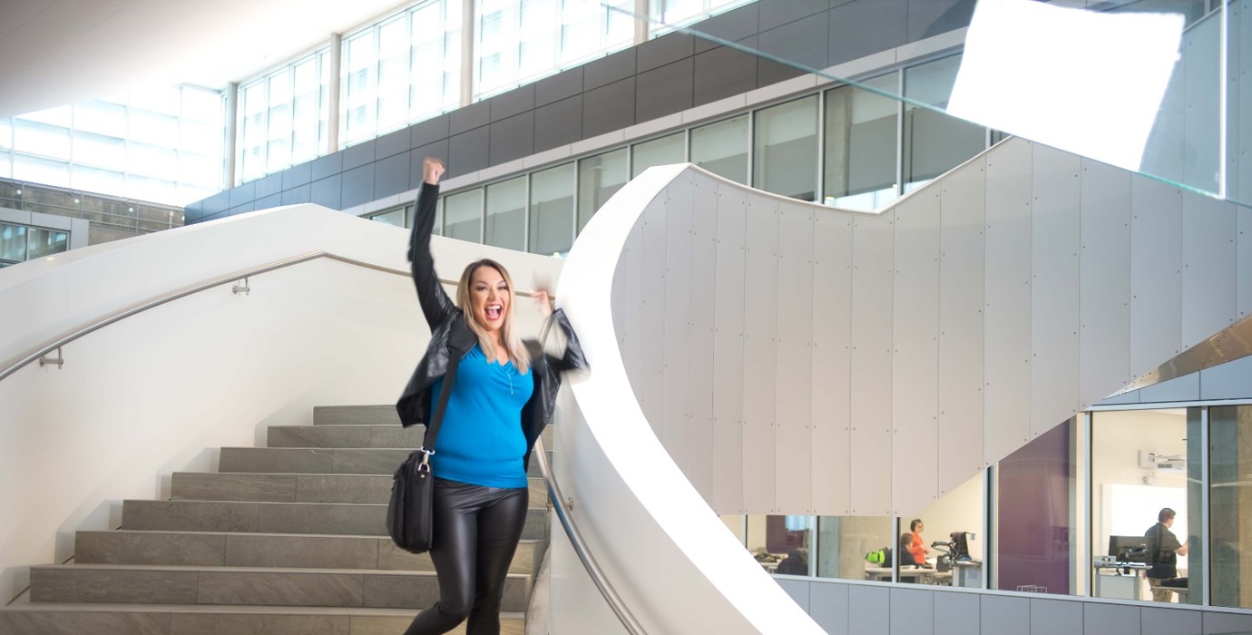 Student happily walking down the stairs with a fist pump